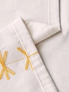 Macro shot of embroidered yellow floral patterns on linen-style waterproof tablecloth