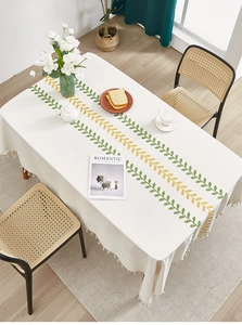 Detail of Nordic cotton linen tablecloth with leaf pattern and elegant beige tassels
