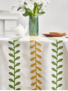 Detailed view of the fine leaf embroidery on the cream cotton linen tablecloth