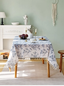 Detail der nordischen Retro-Tischdecke aus Baumwollleinen mit beigen Quasten und blauem Blumendruck