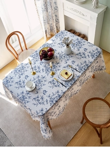 Detailaufnahme der rechteckigen Leinentischdecke mit blauem Blumendruck und Fransen