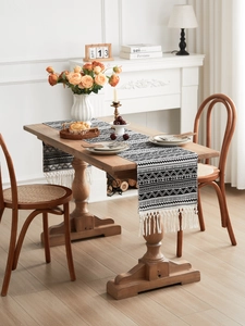 Close-up of black and white geometric table runner with handmade cotton tassels