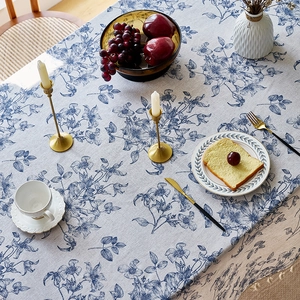 Rechteckige Tischdecke aus Leinen mit blauen Blumenmustern und beigen Quasten auf Holztisch