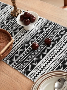 Close-up of black and white geometric woven table runner with boho tassels and texture