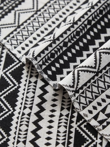 Close-up of geometric woven table runner fabric with black and white tribal patterns