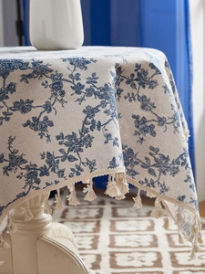 Detailed texture of cotton linen floral tablecloth featuring elegant fringe tassels