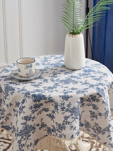 Close-up of French floral cotton linen tablecloth with elegant pom-pom fringe details