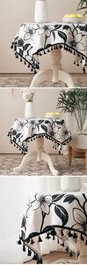 Detailed view of floral linen round tablecloth featuring black fringe edges and patterns