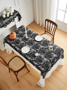 Detail of black lace Halloween tablecloth with intricate skull and floral motifs