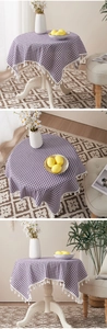 Detail of purple gingham cotton linen tablecloth featuring decorative white tassels
