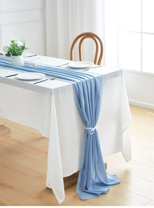 Close-up of light blue chiffon table runner with elegant soft draped folds on white linen
