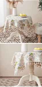 Detailed close-up of floral cotton linen tablecloth with delicate white fringe edges