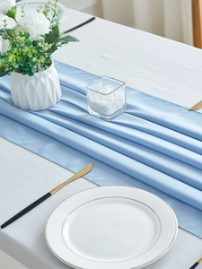 Detail of light blue chiffon table runner with elegant folds for dining table decor