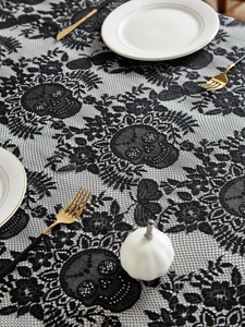 Close-up of black lace Halloween tablecloth featuring skull and floral jacquard patterns