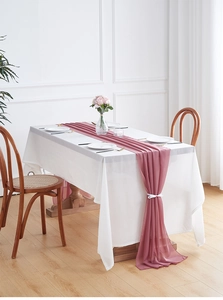 Detail of elegant dusty rose chiffon table runner with decorative white ribbon ties