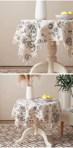 Detail of round cotton linen tablecloth with floral prints and elegant tassel edges