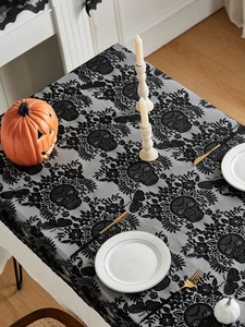 Detailed view of Halloween black lace tablecloth featuring skull and vine floral patterns