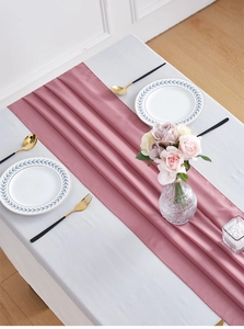 Close-up of elegant dusty pink chiffon table runner with soft silk texture and natural folds