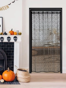 Detailed view of Halloween lace door curtain with spider webs and skull patterns