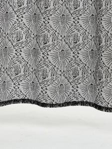 Macro detail of black lace curtain featuring spooky ghost hand and floral mesh patterns