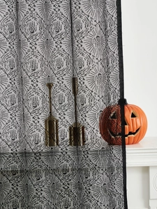 Detail of Halloween black lace curtain with spooky handprint pattern and mesh texture