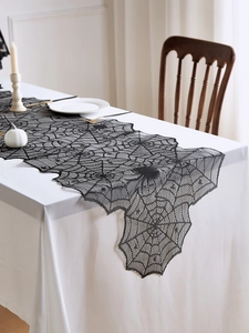Détail d'un chemin de table en dentelle noire avec motif de toile d'araignée Halloween