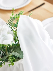 Close-up of lightweight white chiffon table runner with fine overlock stitching details