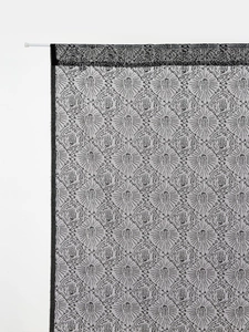 Detail of Halloween black lace curtain featuring spooky eye patterns and rod pocket header