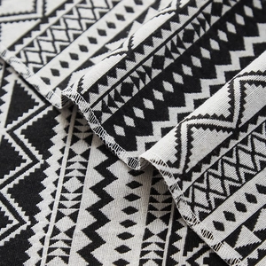 Modern black and white woven table runner with geometric diamond patterns and tassels