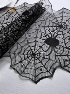 Détail du chemin de table en dentelle noire avec motifs d'araignée d'Halloween