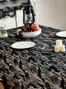 Detail of Halloween black lace tablecloth with spider webs, skulls, bats, and Trick or Treat text