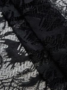 Detail of black lace Halloween tablecloth with intricate bat and floral mesh patterns