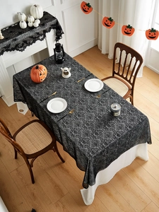 Dettaglio di tovaglia in pizzo nero per Halloween con ragnatele e decoro festivo