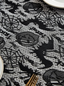 Detail of Halloween black lace tablecloth with bats, pumpkins and festive patterns