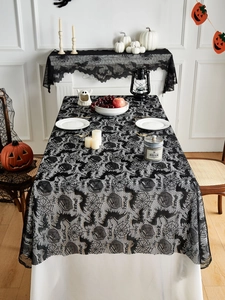 Close-up of black lace tablecloth with spider web and bat motifs for Halloween party