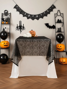 Dettaglio tovaglia di Halloween in pizzo nero con motivi a ragnatela e teschio
