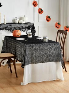 Dettaglio di tovaglia di Halloween in pizzo nero con ragnatele e motivi floreali