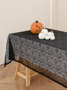 Dettaglio della tovaglia di Halloween in pizzo nero con motivi a ragnatela e oro