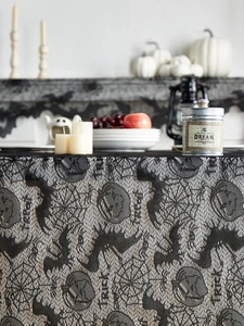 Close-up of black lace Halloween tablecloth with bats, spiders and Trick or Treat motif