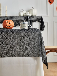 Dettaglio della tovaglia di Halloween in pizzo nero con motivi a ragnatela e fiori retrò
