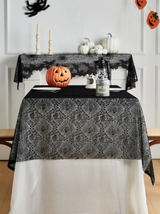 Dettaglio di tovaglia in pizzo nero con motivi a ragnatela e pipistrelli per Halloween