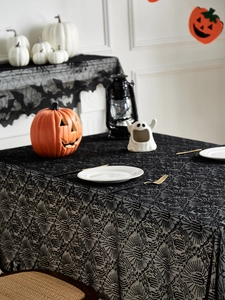 Dettaglio tovaglia gotica in pizzo nero con motivi a ragnatela e pipistrello per Halloween