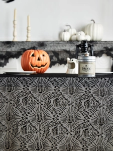 Dettaglio della tovaglia di pizzo nero per Halloween con ragnatele e teschi decorati