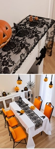 Detail of black lace Halloween table runner featuring intricate skull and vine patterns