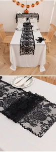 Close-up of black lace Halloween table runner featuring intricate skull and web patterns