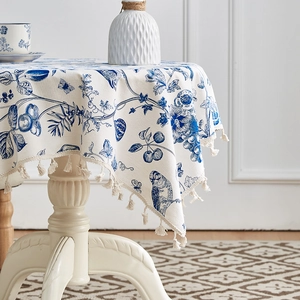 Detail einer blau geblümten Tischdecke aus Baumwolle und Leinen mit eleganten Quasten