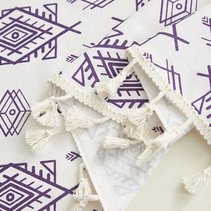 Detail of bohemian purple geometric print on fabric with decorative cotton tassels
