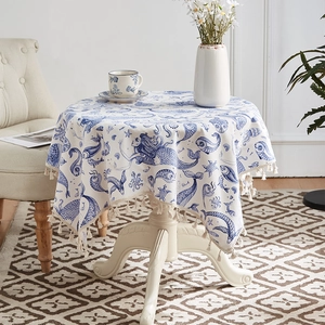 Detail of round cotton linen tablecloth with blue ocean mermaid print and fringe tassels