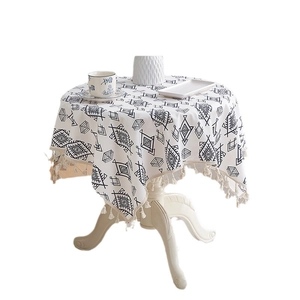 Round beige cotton linen tablecloth with black geometric patterns and fringe edges