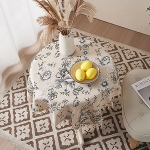 Detailed texture of linen tablecloth featuring retro ink flower patterns and beige tassels